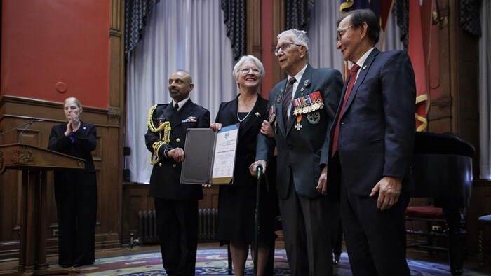 Edith Dumont remet un prix à des aînés lors d'une cérémonie.