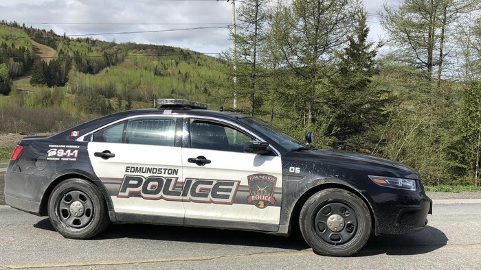 Une voiture du service policier municipal barre la route devant le centre de ski.