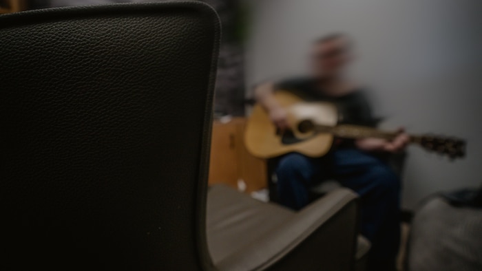 Un jeune joue de la guitare.