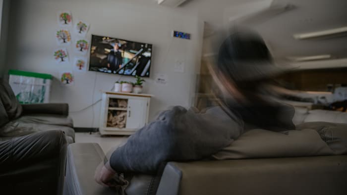Un jeune écoute la télé.