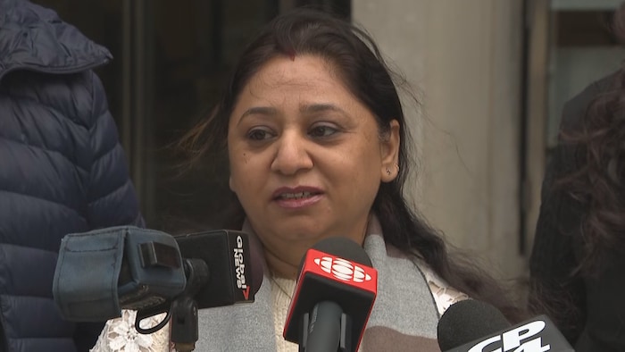 Pooja Vasudev devant un micro.