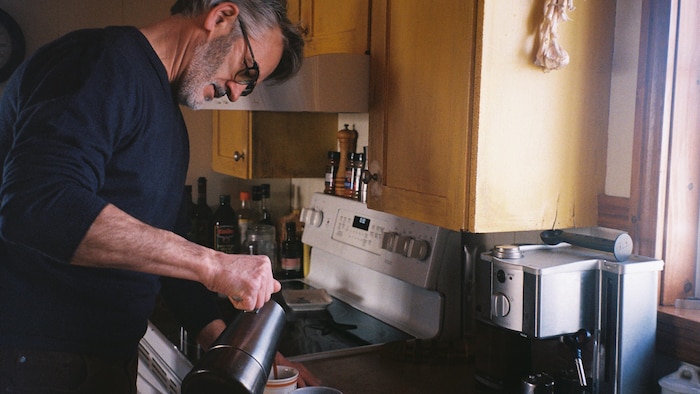 Égide Leblanc, un Madelinot de Pointe-aux-Loups, verse du café dans des tasses.