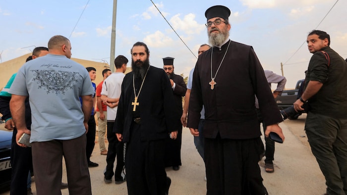 Deux hommes en habits de prêtres orthodoxes.