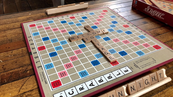 jeu de scrabble sur une table en bois où les mots welcome et cottage sont inscrits