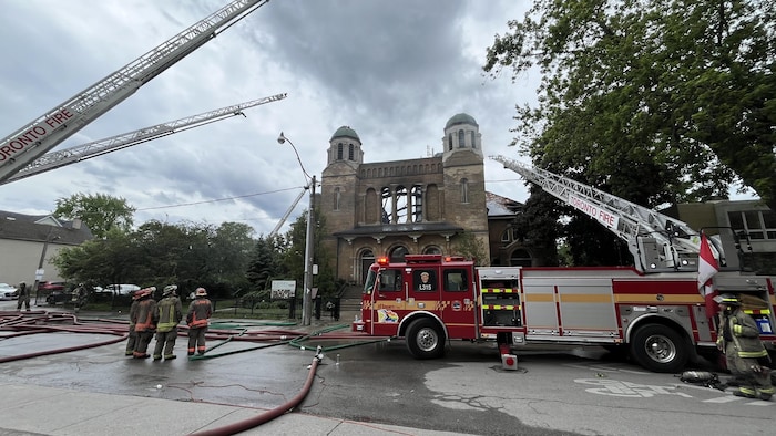 Des équipements de service d'incendie et des pompiers devant l'église.