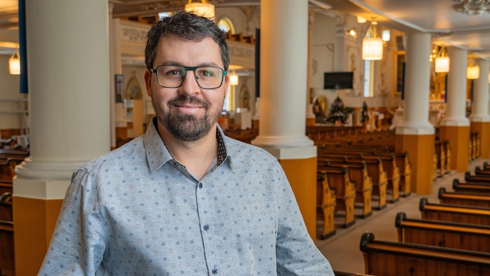 Nicolas Bradette est photographié entre les bancs de l'église. 