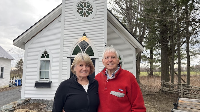 Deux personnes regardant devant, avec l'église derrière eux.