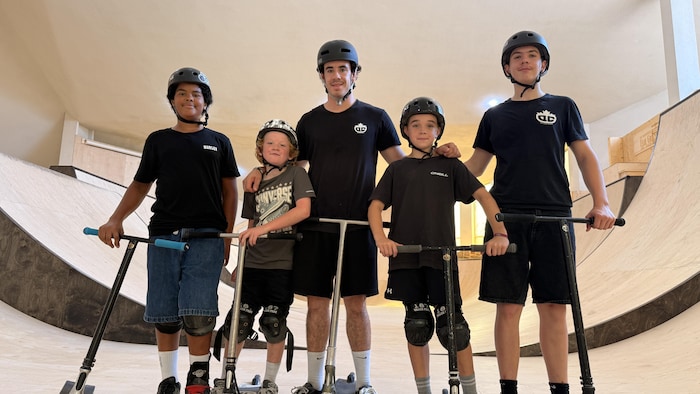 Cinq jeunes sportifs accompagnés de leur trottinette.