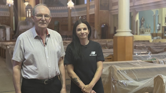 Deux personnes prennent la pose dans une église en rénovation. 