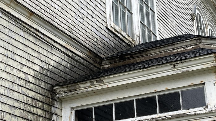 Le mur extérieur d'une église en bois est noirci et moisi.
