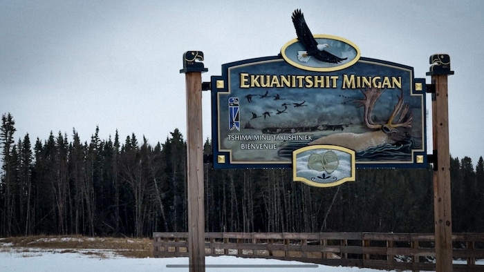 Une affiche annonce l'entrée d'un village.
