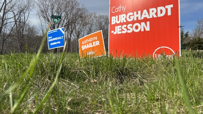 Des pancartes pour la candidate libérale Cathy Burghardt-Jesson, la néo-démocrate Kathryn Shailer et le candidat conservateur Steve Pinsonneault.