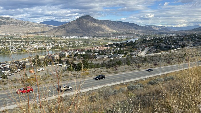 Une partie de la ville de Kamloops avec une route en premier plan et une montagne en arrière plan. 