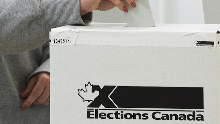 Una persona deposita un voto.