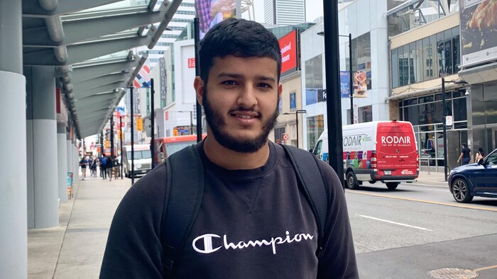 Un jeune homme à l'extérieur, au centre-ville de Toronto.