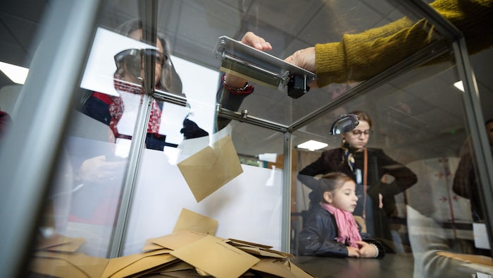 Une électrice dépose son bulletin de vote au premier tour des élections municipales françaises de 2026 à Marseille, dans le sud de la France. 