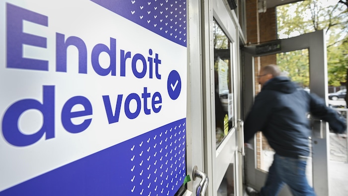 Une personne arrive à un bureau de vote à Montréal, le dimanche 26 octobre 2025, pour voter par anticipation en vue des élections municipales du 2 novembre.