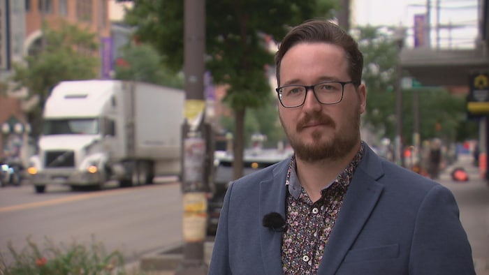 Un homme en entrevue télé dans la rue.