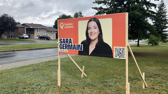 Une affiche électorale, au bord d'un boulevard, montrant la photo de Sara Germain, de Québec solidaire.