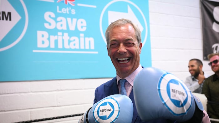 Nigel Farage wears boxing gloves.