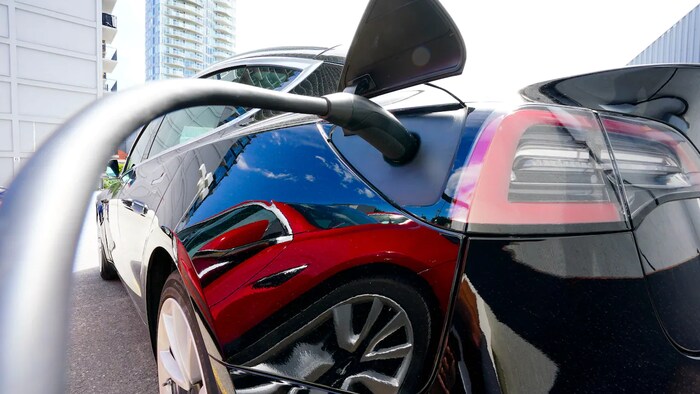 Isang electric vehicle na nakakabit sa charger.