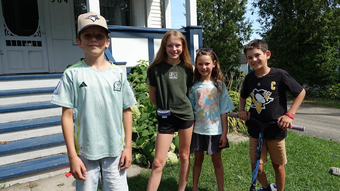 Quatre enfants devant une maison.