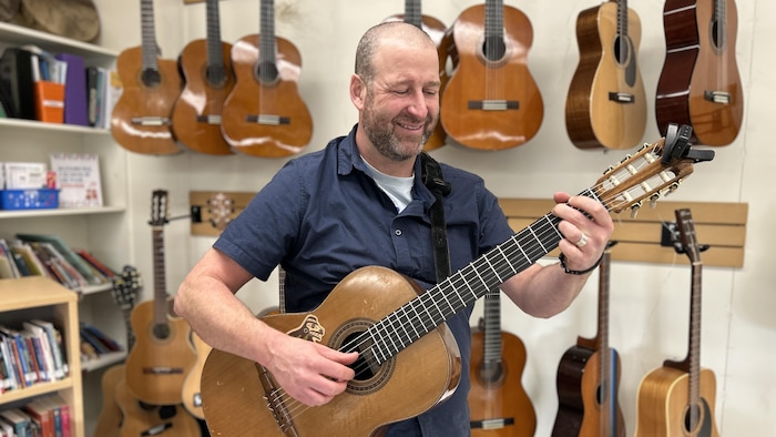 L'enseignant Marc-Olivier Chouinard joue de la guitare.
