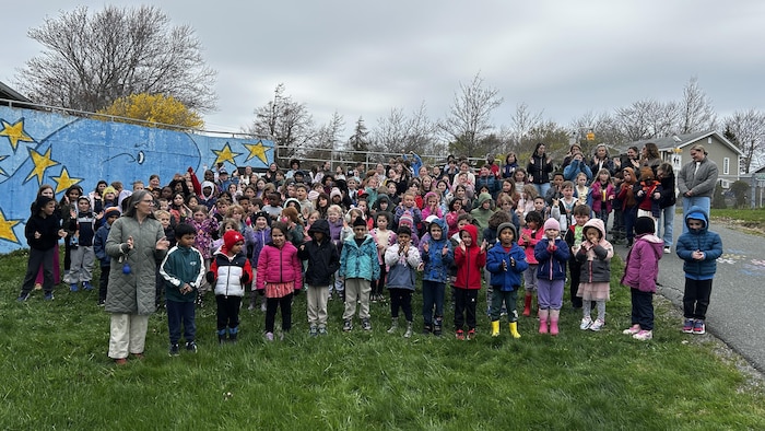 Près de 200 enfants rassemblés sur le terrain de l'école.