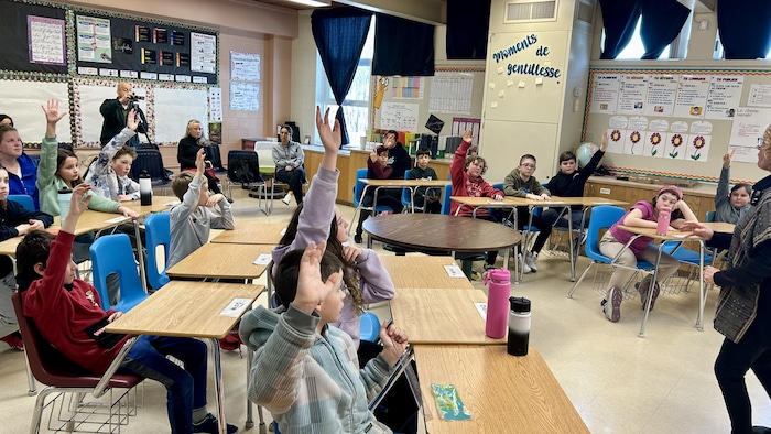  Des élèves de l'école Notre-Dame Hanmer lèvent la main pour poser des questions.