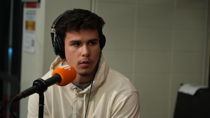 Éliott Bilodeau est derrière un micro de Radio-Canada lors d'une émission spéciale de l'émission Première heure, le 4 septembre 2026, au Cégep Limoilou.