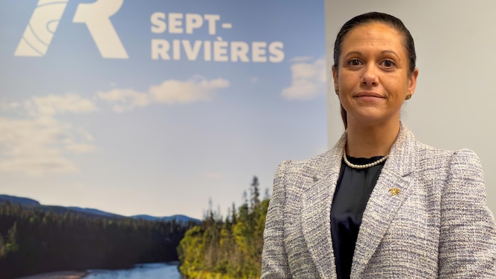 Élisabeth Chevalier devant une pancarte de la MRC de Sept-Rivières.