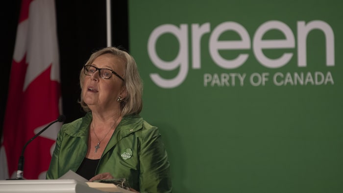 Elizabeth May parle dans un micro. 