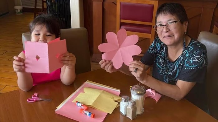 Elizabeth Michel enseigne à sa petite-fille, Markaylee, l'art de faire des fleurs dans un hôtel de Saskatoon.