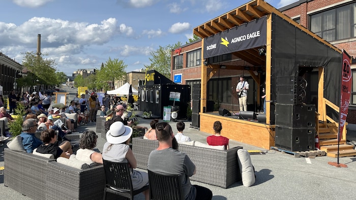 Une vingtaine de personnes assistent au spectacle extérieur d'Elliot P et Jeanne Perrin en spectacle au Festival des guitares du monde en Abitibi-Témiscamingue.