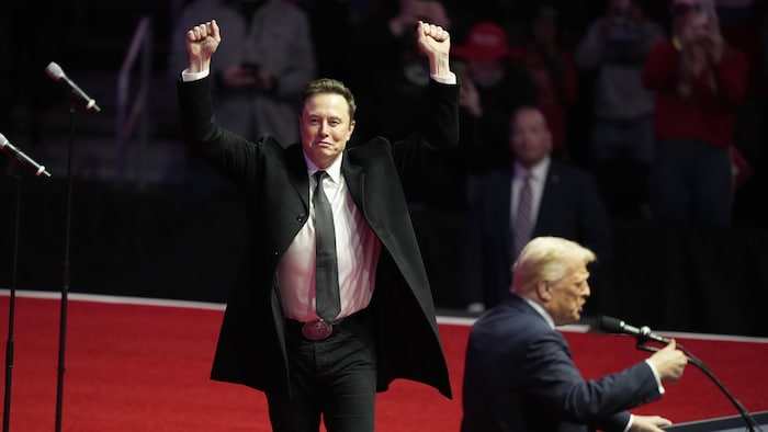M. Musk lève les bras, tandis que M. Trump s'adresse à la foule.