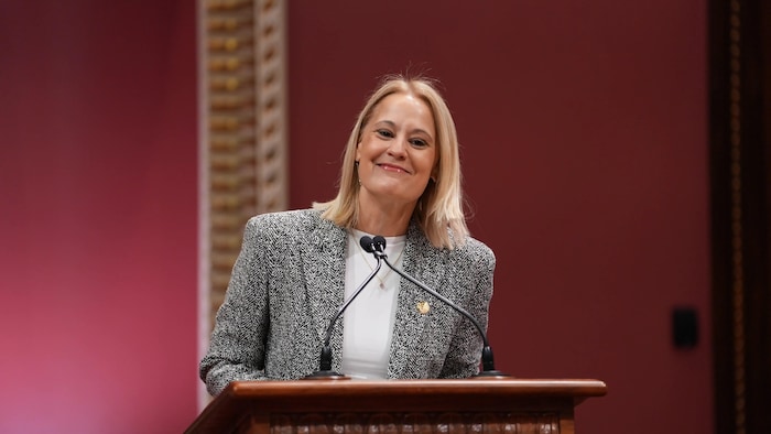 Elsie Lefebvre souriante devant un lutrin.