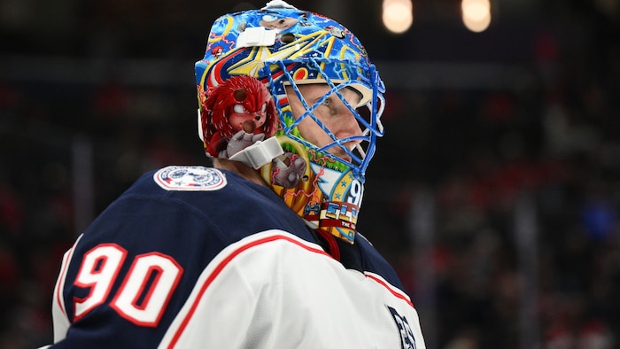 Elvis Merzlikins dans l'uniforme des Blue Jackets sur la glace.