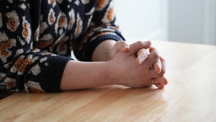 Elyse Lafortune croise les mains sur une table.