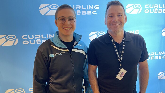 Deux hommes souriants, debout et un arrière-plan bleu sur lequel est écrit curling Québec