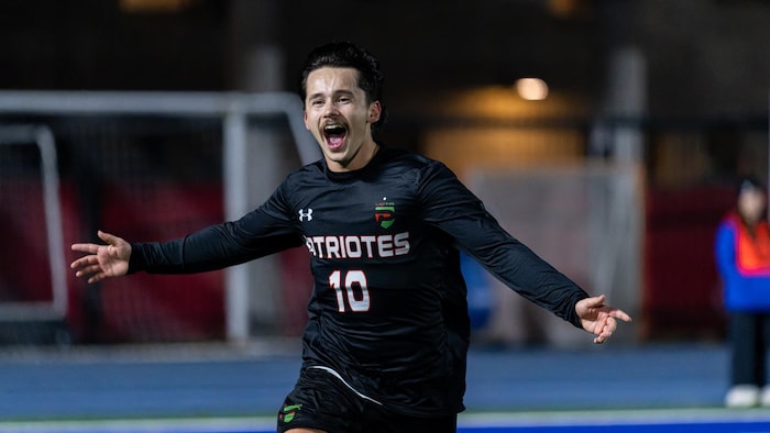 Un joueur de shot portant le chandail numéro 10 célèbre avec les bras élevés de chaque côté de lad corps.