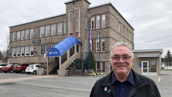 Émile Hudon se trouve devant l'hôtel de ville de Saint-Gédéon.