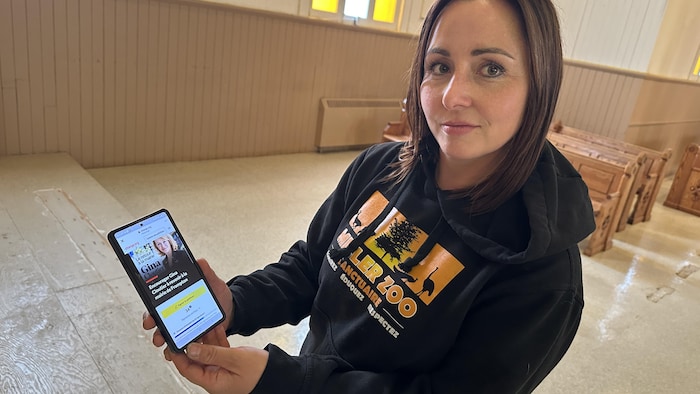 Une femme tient un téléphone dans une église.