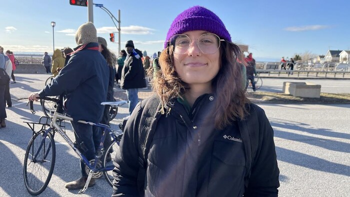Émilie Laliberté se tient dans la rue devant d'autres manifestants.
