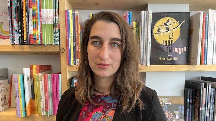 Émilise Lessard-Therrien entourée de livres dans une librairie.