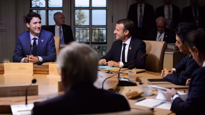 Emmanuel Macron et Justin Trudeau discutent autour d'une table au G7.