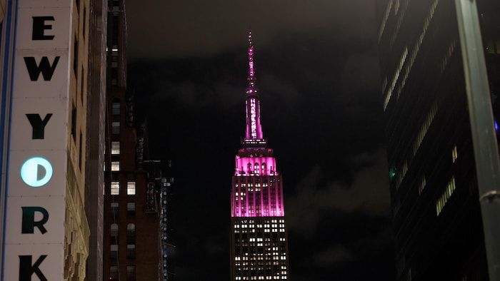 Le célèbre édifice illuminé en rose, la nuit.