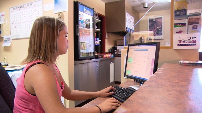 Une jeune femme qui travaille sur un ordinateur.