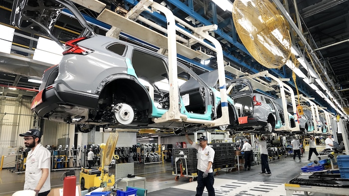 Des employés de Honda travaillent sur la chaîne de montage des véhicules dans une usine.