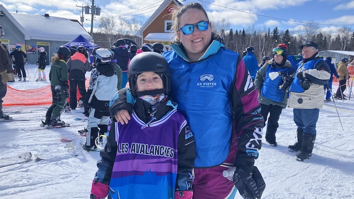 Camille Chevrier et sa fille de 9 ans, Lexie Bolduc, habillées pour le ski alpin, posent pour la caméra en souriant.