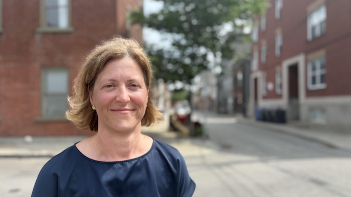 Cathy Dubé sourit à la caméra dans une rue de Québec.